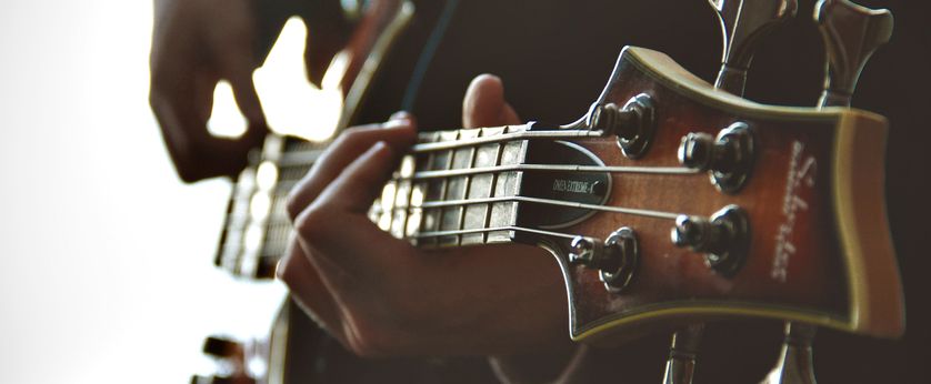 Hands playing bass guitar.