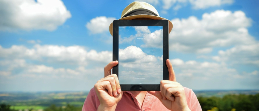 man holding an iPad in front of his face