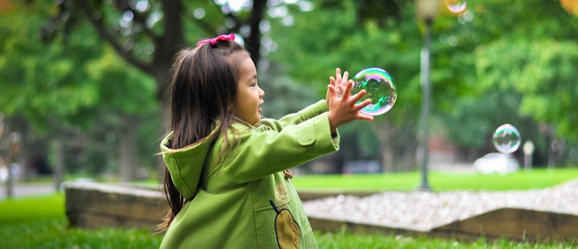 child chasing bubbles