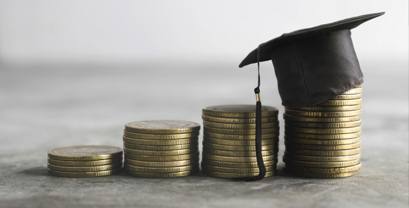 stack of coins and graduation cap